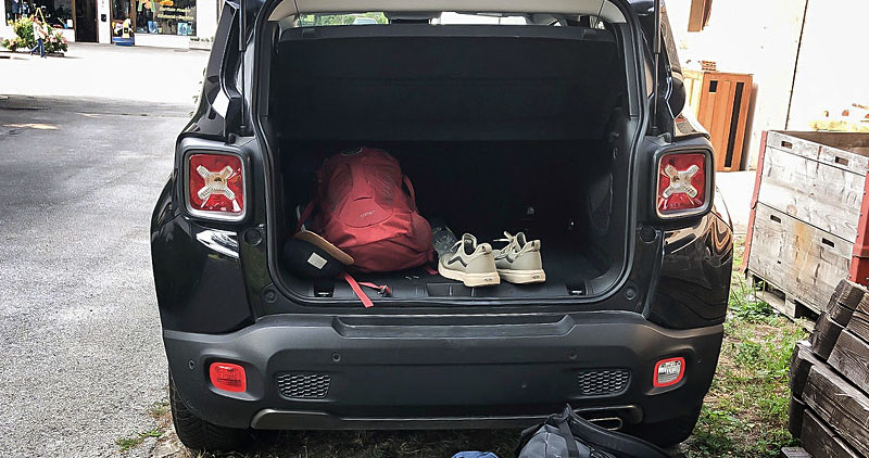 A car with a backpack and sneakers in the back