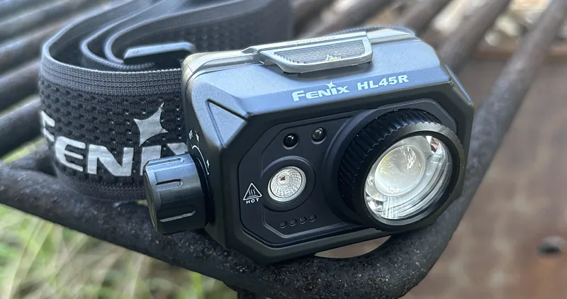 Fenix HL45R Headlamp sitting on a campfire grate