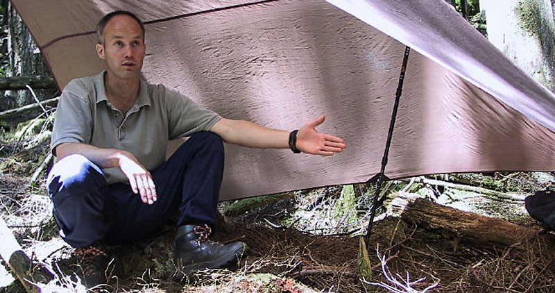 Canada West Mountain School: a man explaining how to setup a shelter with a tarp and hiking pole