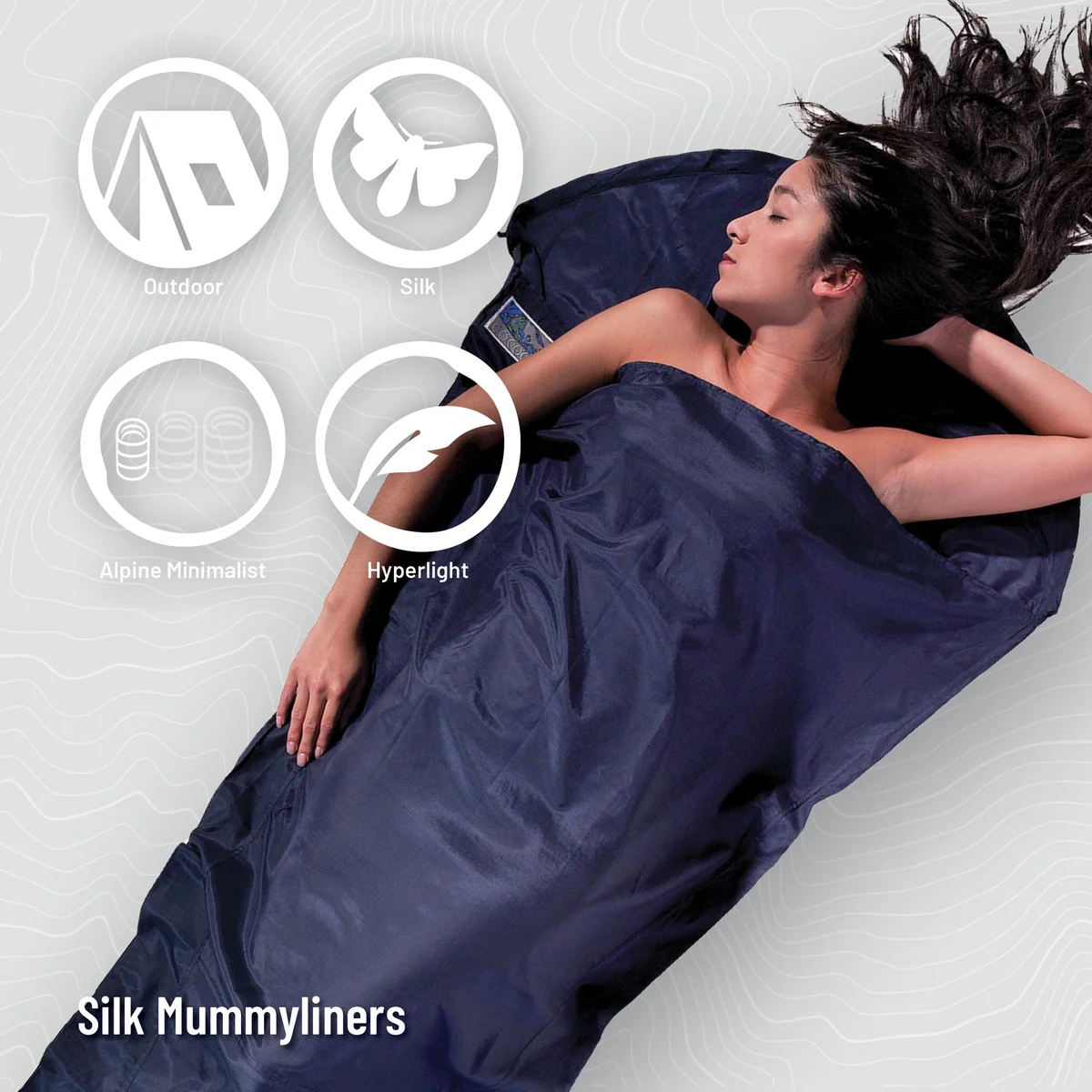 COCOON MummyLiner Silk laid out next to its stuff sack, showing compact packed size
