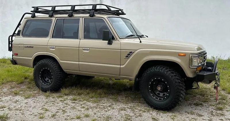 Toyota Land Cruiser with a roof rack and all-terrain tires, a top-recommended reliable bug out vehicle