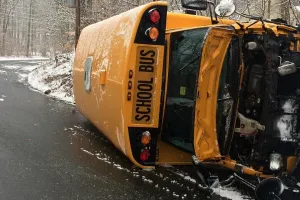 Crashed school bus on its side on a snow covered highway