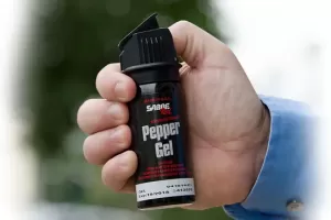A mans hand holding a can of pepper spray